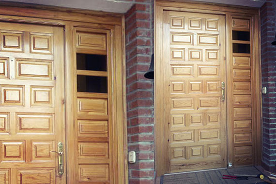 Esta puerta convencional fue reconvertida en una puerta blindada aprovechando el existente cerraje de seguridad y reforzando por ambas caras con chapas de acero adheridas y atornilladas, posteriormente recubiertas (por ambas caras igualmente) por un tablero decorativo blanco. La parte fija de la puerta se convirtió en un tragaluz sustituyendo los cuarerones de madera por unos cristales blindados de seguridad con una lámina traslúcida, proporcionando al recibidor una mayor luminosidad y calidez. El marco y las jambas también fueron pintados en blanco. La manilla fue sustituida por una más acorde al nuevo diseño de la puerta, dando al conjunto un aire actual y proporcionando una mayor seguridad al hogar.