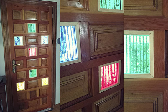 Con la intención de darle más luz al recibidor y un toque de color, los cuarterones de madera de la puerta fueron sustituidos por cristales de seguridad de colores diversos de forma alterna, dando una apariencia de mosaico y vidriera (los colores fueron elegidos por el cliente). Sin duda proporcionó un ambiente más rico con un toque personal.