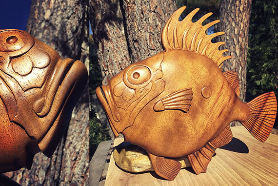 Talla realizada en madera de iroko. La figura representada es el pez de San Pedro de leyenda que habla sobre el pez capturado en el mar de Galilea por San Pedro, el cual contiene una marca que supuestamente se la hizo el apostol con el pulgar cuando sujetaba el pez.