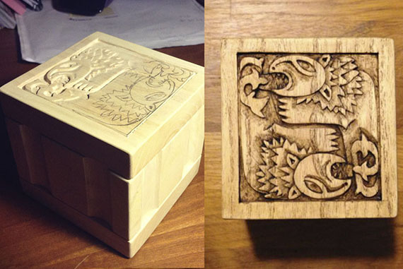 Esta pequeña caja de música realizada en madera fresno con una talla en bajo relieve representando dos figuras de leones celtas unidos de forma circular inspirado en un diseño de una antigua espada celta.  Esta caja (como su nombre indica) contiene un mecanismo de manivela que acciona un mecanismo musical arpa mecánica.