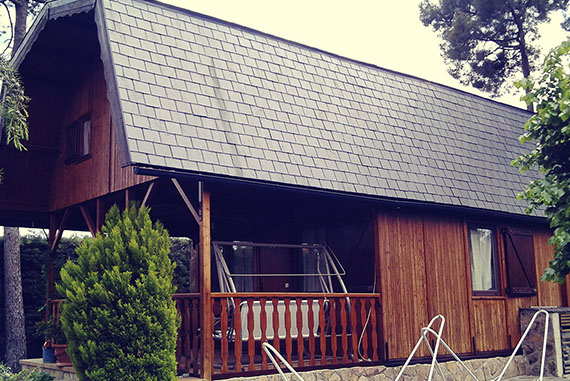 Esta casa presentaba un grave deterioro de su fachada, contraventanas, puertas, columnas y barandillas, a causa de la lluvia y el Sol junto con un nulo mantenimiento. La ardua restauración de las maderas requiso un profundo y meticuloso lijado hasta llegar a la madera sana eliminando la capa de madera en mal estado. El alero de los frontales se reafirmó añadiendo nuevos tornillos aportando mayor solidez a la casa. Toda la parte metálica de la casa (herrajes, manillas, aspas, bisagras, anclajes, escuadras… etc) fueron pulidas y repintadas con martelé negro. El acabado final de la madera fue con un doble tratamiento de imprimación y terminada con lasur de roble claro, proporcionando de esta manera la protección necesaria contra las inclemencias del tiempo, alargando la vida de la casa y evitando un inminente deterioro sin vuelta atrás de la casa. Restableciendo así la natural belleza de la madera.